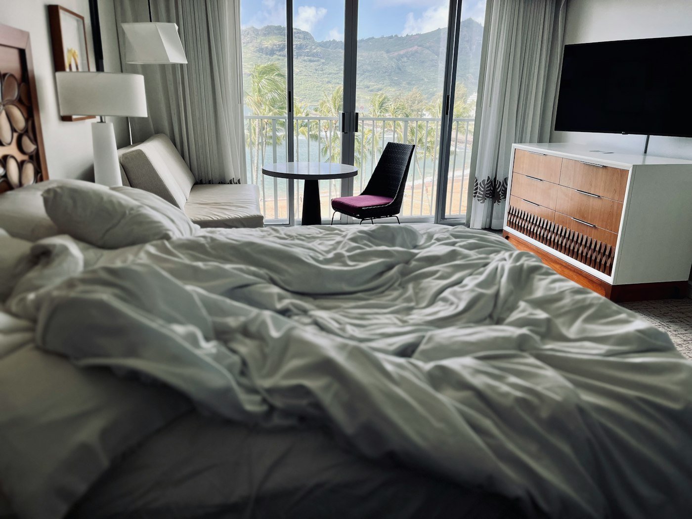 A bedroom with a large bed and a balcony door