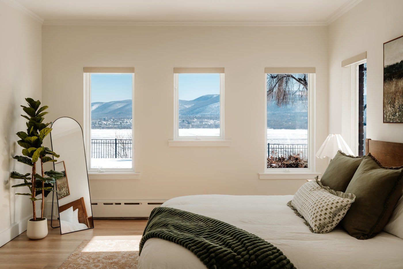 A bedroom with a window looking out over a valley